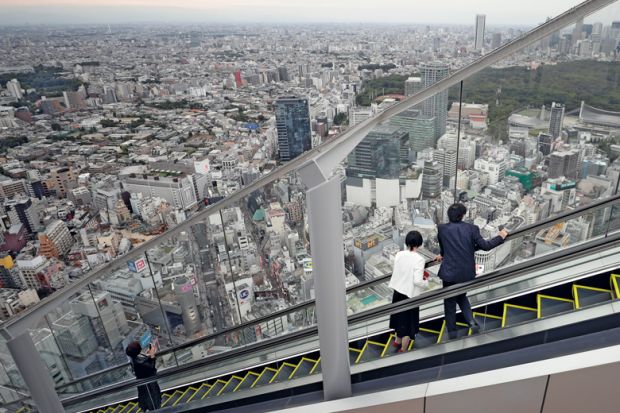 Visitors look out at the view while riding up an escalator at the Shibuya Sky observation deck in Tokyo Visitors look out at the view while riding up an escalator at the Shibuya Sky observation deck in Tokyo to illustrate Students protest as Japanese universities mull tuition fee hikes