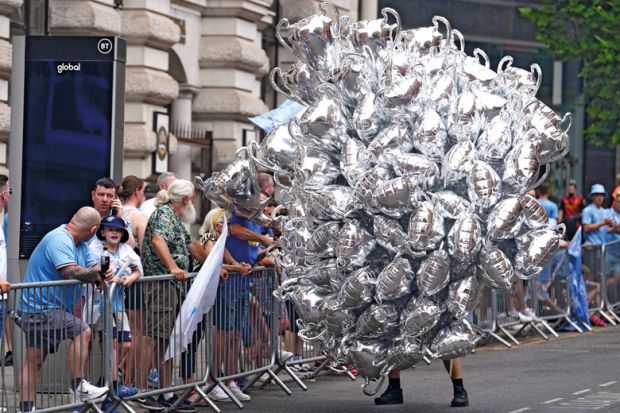  A street vendor with trophy balloons to illustrate Students rate UK courses highly despite challenges