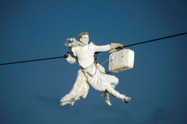 A performer is suspended from high-wires during the outdoor aerial performance of a show A performer is suspended from high-wires during the outdoor aerial performance of a show