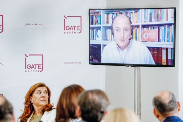 Person speaks via videoconference during an in person meeting to illustrate Conferences don’t see a hybrid future