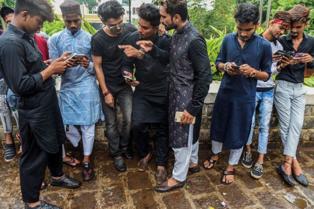 Group of people looking at their phones in Mumbai Group of people looking at their phones in Mumbai to illustrate Deadline looms for India’s national academic credit bank