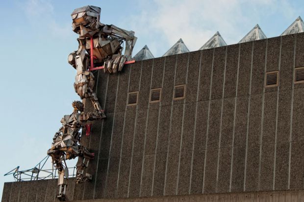Robot sculptures climbing up the Hayward Gallery, London Robot sculptures climbing up the Hayward Gallery, London to illustrate Germany’s largest university buys UK college and degree powers