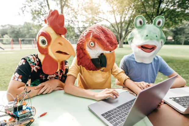 Three people wearing head costume masks looking at laptops Three people wearing head costume masks looking at laptops as a metaphor for Cheating firms offer Zoom proxy