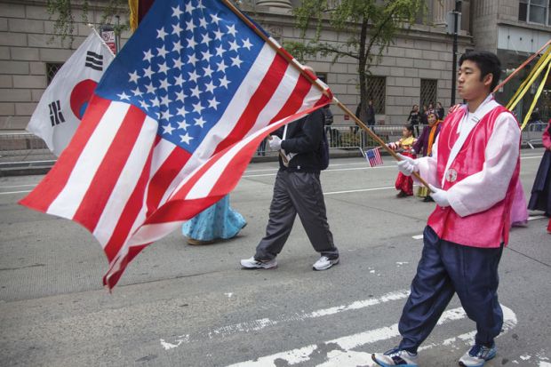 Annual Korean Day Parade man holding American flag Annual Korean Day Parade man holding American flag to illustrate ‘High stakes’ and hurdles ahead for KAIST’s New York campus