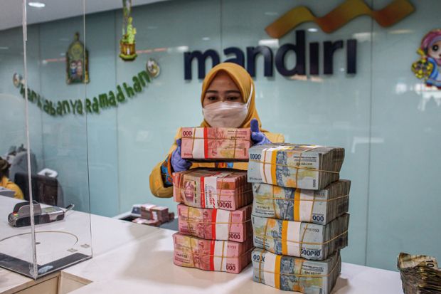 A woman arranges bundles of Indonesian rupiah banknotes at Mandiri Mikro Business Unit Bandung Braga in Bandung A woman arranges bundles of Indonesian rupiah banknotes at Mandiri Mikro Business Unit Bandung Braga in Bandung to illustrate South-east Asian currency slide could hit student mobility