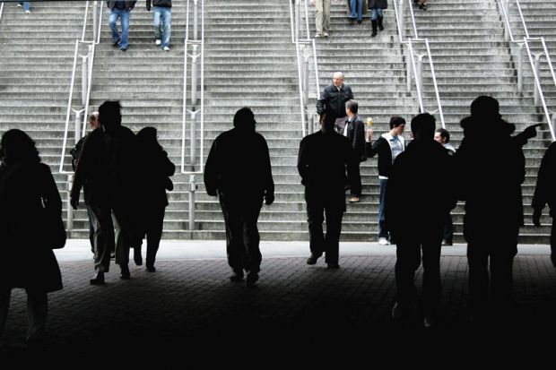 Silhouette of crowd walking towards stairs as a metaphor for more European staff leaving UK for universities abroad post-Brexit