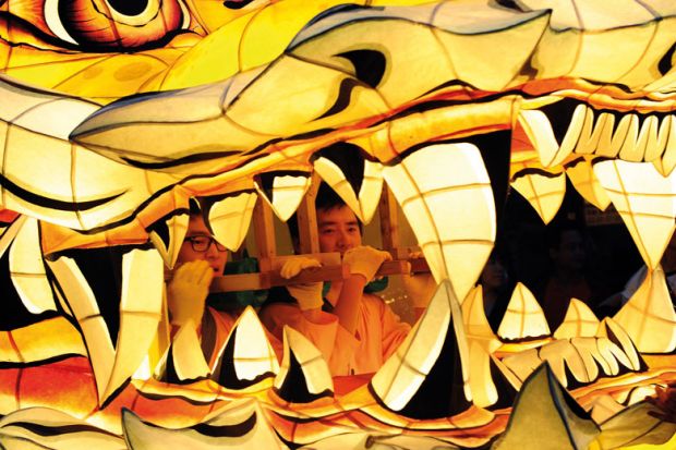 Men are pictured inside the mouth of a float as South Korean Buddhists parade  Men are pictured inside the mouth of a float as South Korean Buddhists parade to illustrate Low-scoring students penalise instructors despite grade inflation