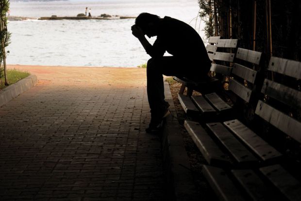 Silhouette of person sitting on a bench as a metaphor for The burned-out suffer in silence