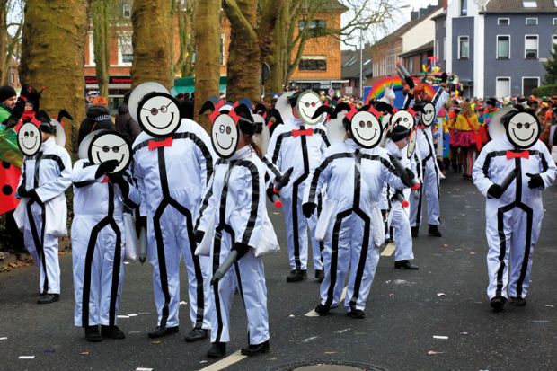 Group of people in same costume wearing same smiling mask. Group of people in same costume wearing same smiling mask as a metaphor for a tool using facial and keystroke recognition has been launched.