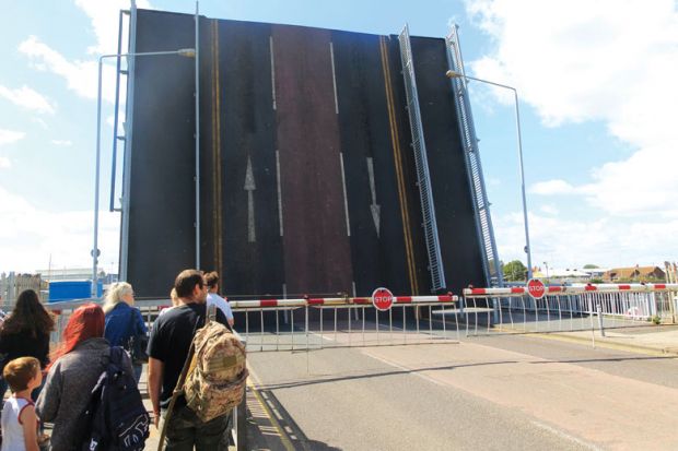 Bridge raised with gates and people waiting to cross ridge raised with gates and people waiting to cross as a metaphor for Overseas research cuts threaten UK’s ‘levelling-up’ agenda.