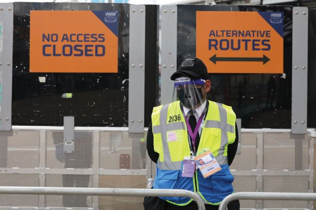 A steward in PPE including face mask and visor as a precaution against COVID-19 staffs a barrier at The London Stadium A steward in PPE including face mask and visor as a precaution against COVID-19 staffs a barrier at The London Stadium