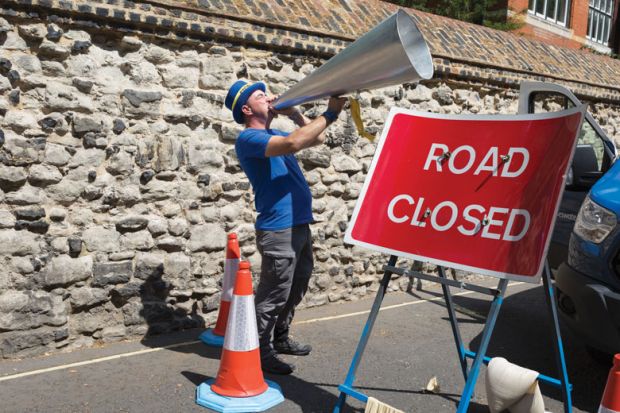 A man shouts through an oversized megaphone with a stop road sign in front of him Man shouts through his oversized megaphone with stop road sign in front of him to illustrate English free speech bill stalls but ministers ‘remain committed