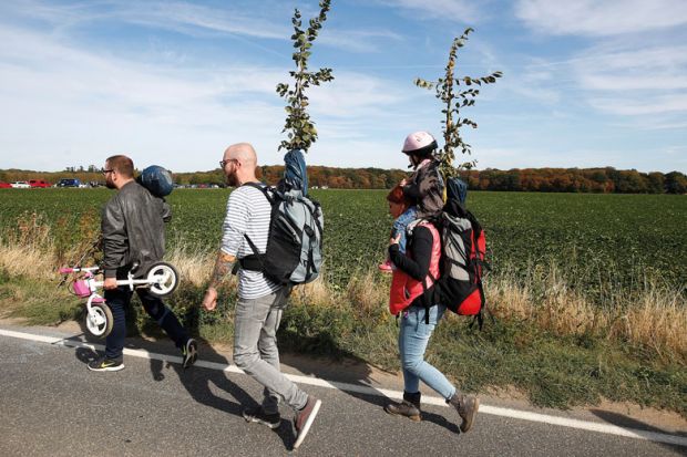 three adults and one child walking three adults and one child walking