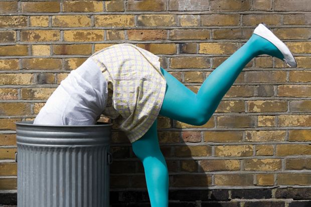 Woman diving into dustbin on street Woman diving into dustbin on street