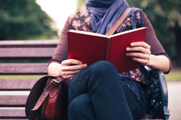 Woman reading on park bench Woman reading on park bench