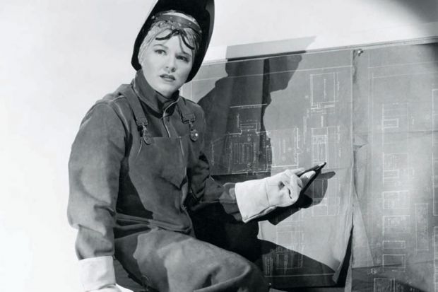 Woman wearing protective clothing pointing at blueprints Woman wearing protective clothing pointing at blueprints