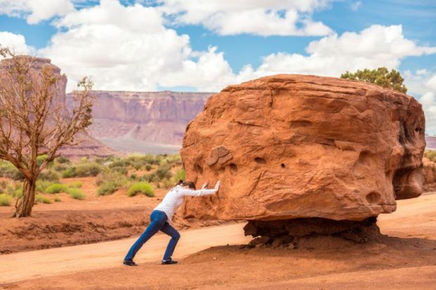 Woman pushing large stone