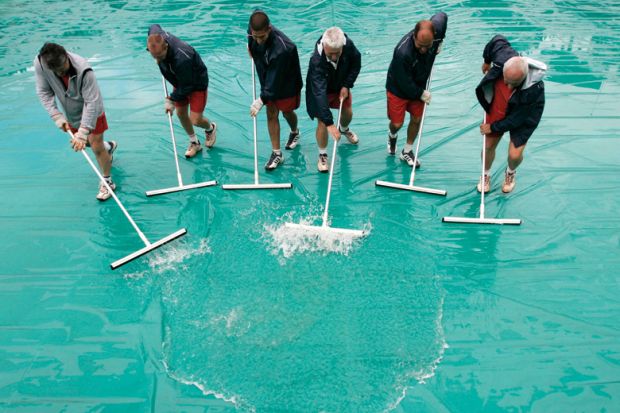 Workers remove water from court, French Open tennis tournament, Paris