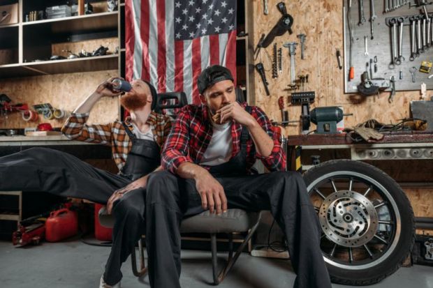 Depressed mechanics in the US, in front of an American flag Depressed mechanics in the US, in front of an American flag