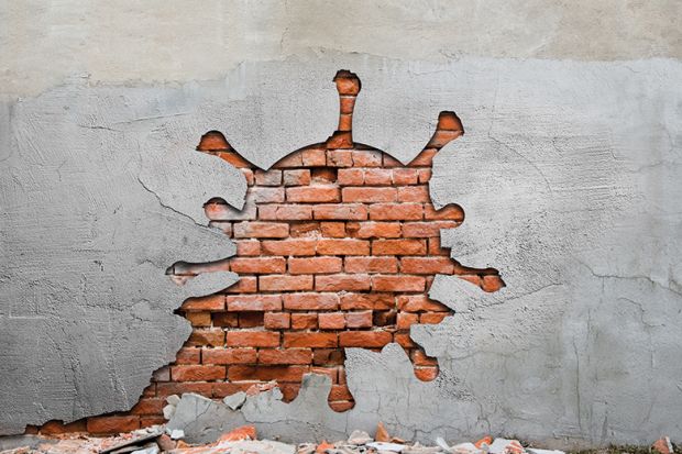wrecking ball Image of coronavirus-shaped hole in a brick wall