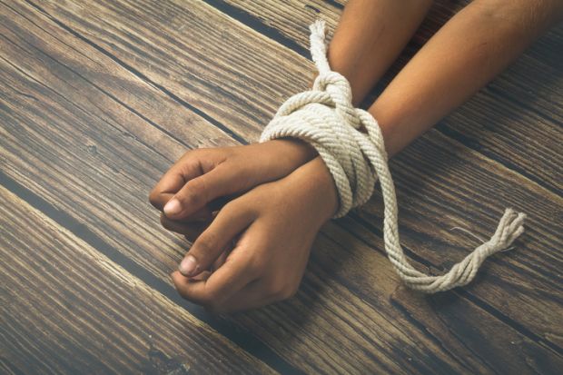 A person’s wrists bound with a rope A person's wrists bound with a rope, symbolising the restriction of academic freedom