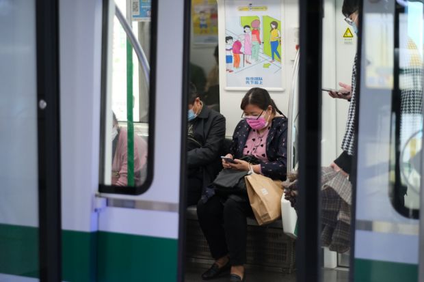 Wuhan China-Oct 2020 passengers in face mask to prevent coronavirus, sitting inside subway train in Wuhan