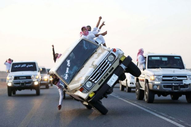 Young men driving on two wheels Young men driving on two wheels