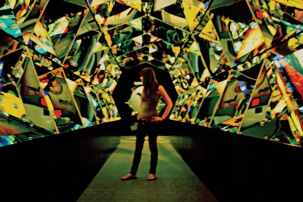 Young woman standing in hall of mirrors Young woman standing in hall of mirrors