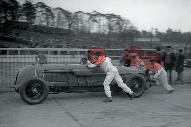 Team of men push-starting race car Team of men push-starting race car